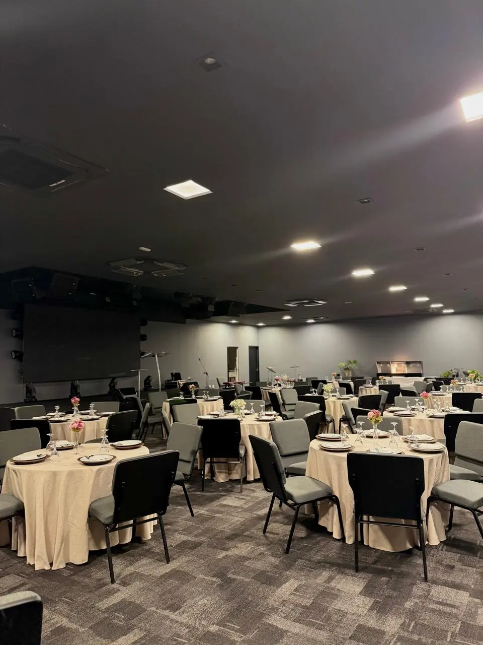 Salão preparado com mesas para uma celebração